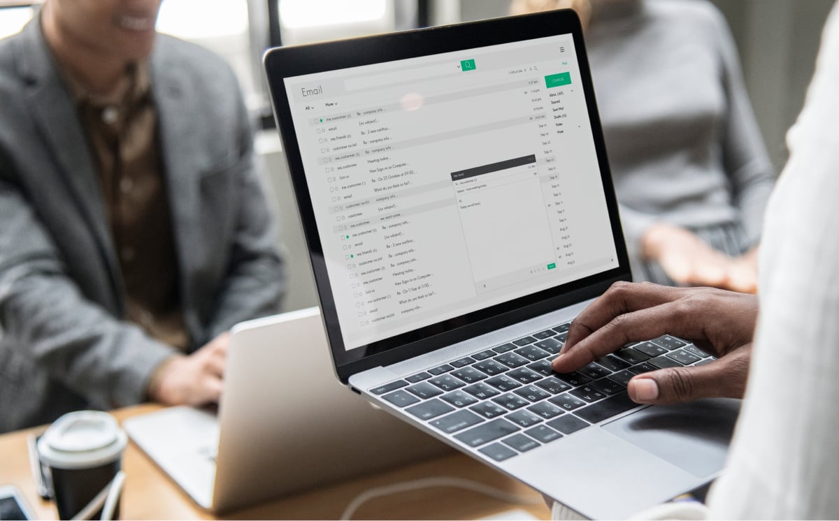 一个人坐在办公桌前，使用笔记本电脑显示明亮的屏幕。