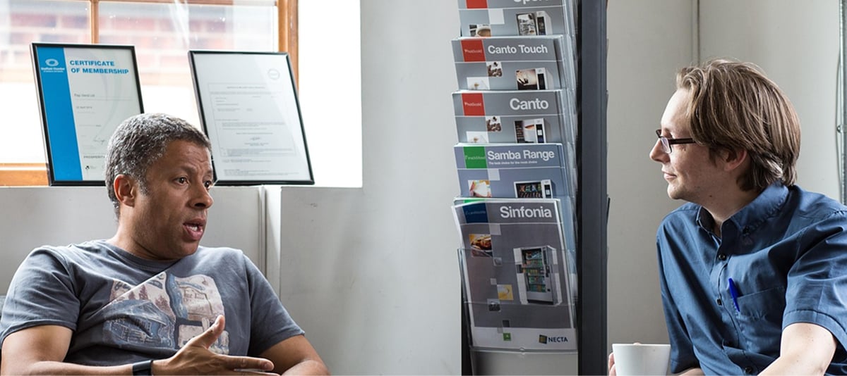 两个人坐在桌边交谈，分享想法和表达方式。